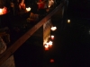 Leute lassen Papierhalter mit Kerze in den Fluss